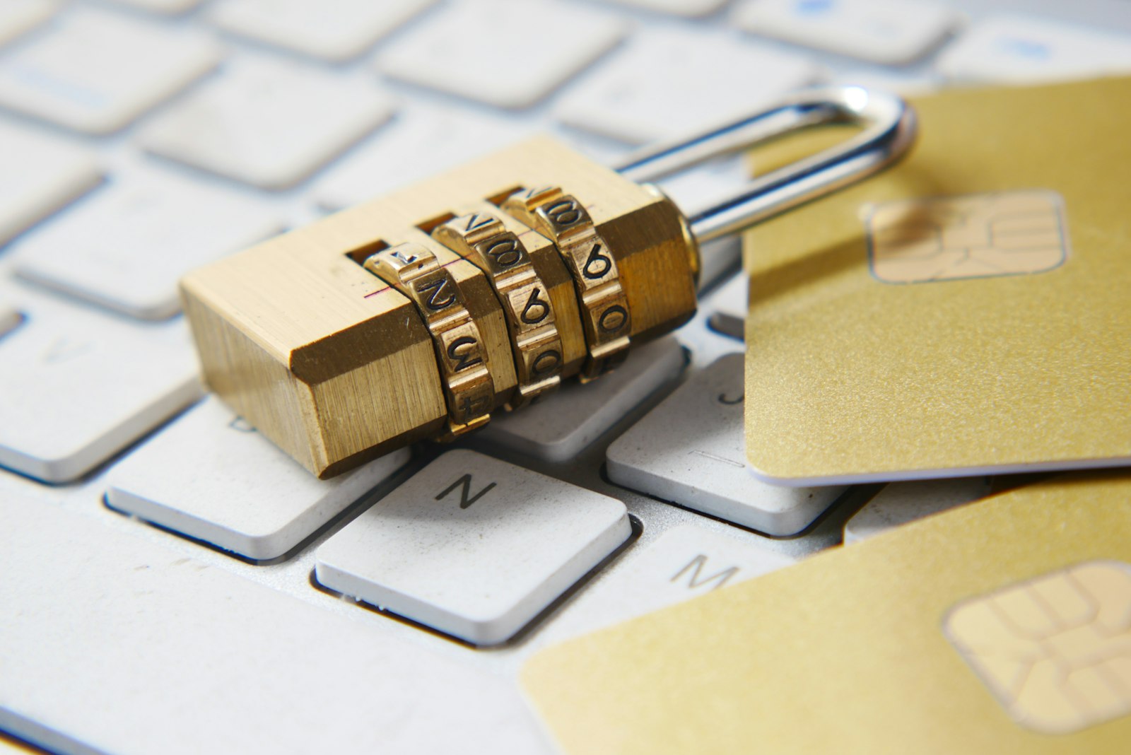 Padlock and payment card on a laptop keyboard, representing personal data protection