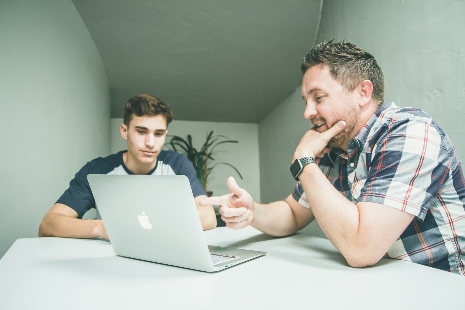 IT specialist helping a colleague at a laptop
