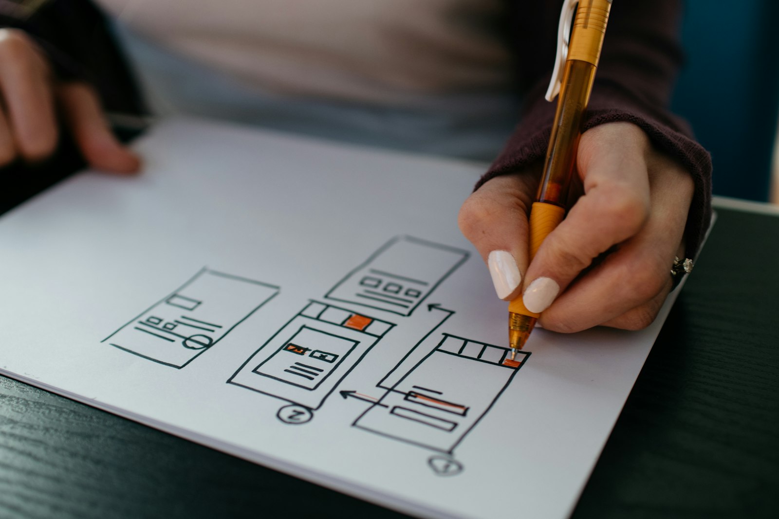 Hand sketching a website wireframe on paper